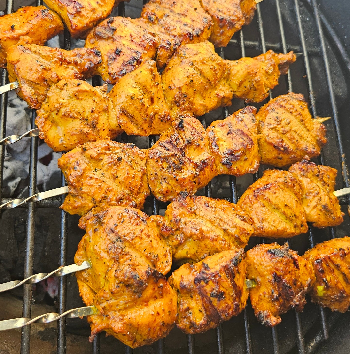 Skewers of marinated chicken on a grill