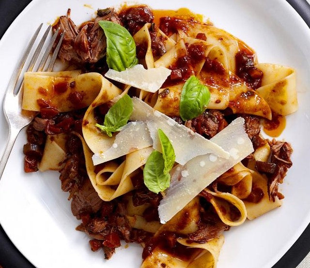 lamb ragu with wide flat noodles and shaved parmesan cheese